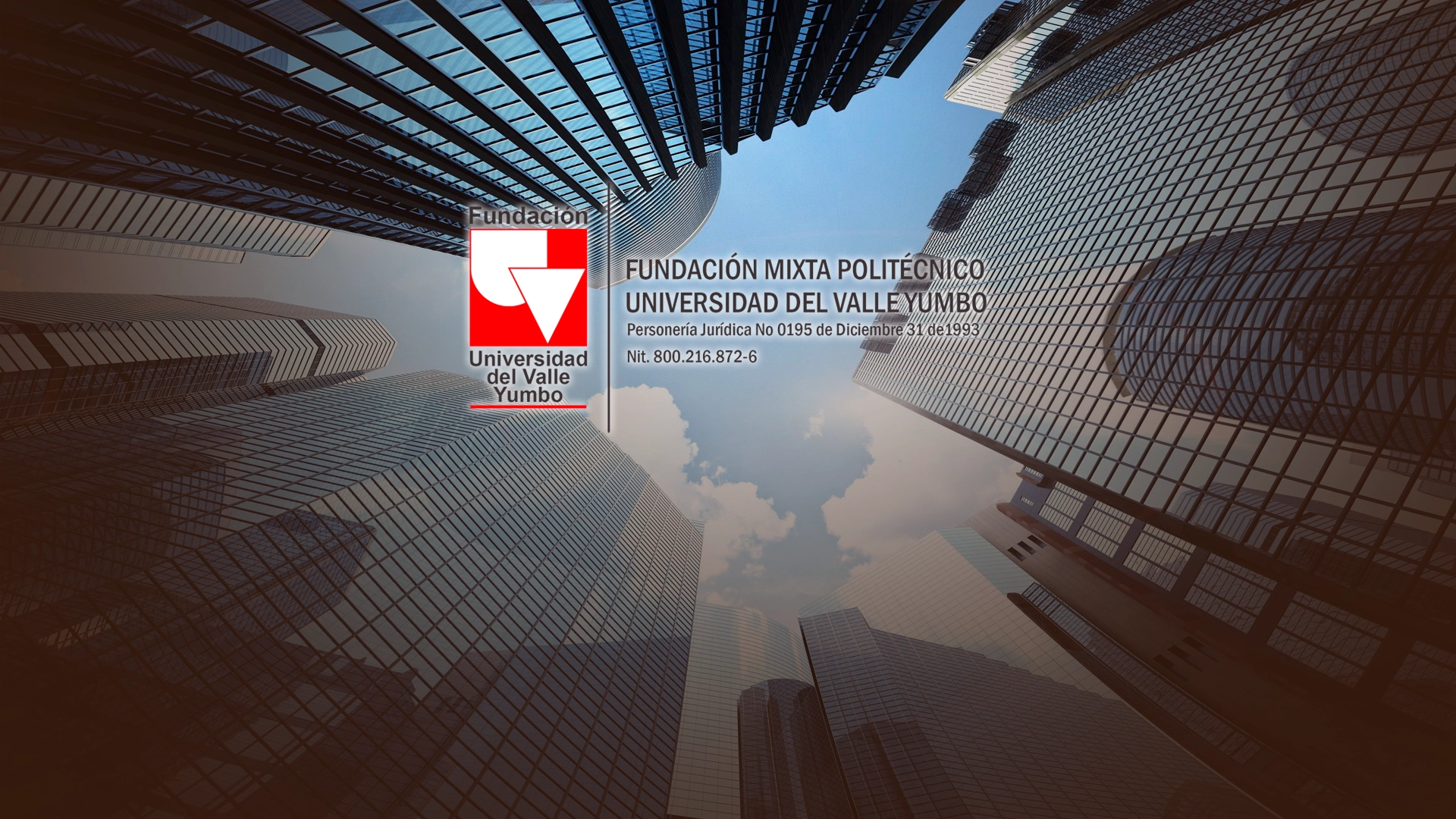 Logo de la Fundación Univalle Yumbo sobre un fondo de edificios modernos vistos desde abajo hacia el cielo